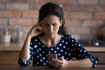 Unhappy woman use cellphone dissatisfied with gadget problem