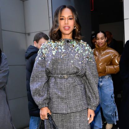a paparazzi photo of a black woman with a short haircut wearing a plaid blouse with jewel embellishments