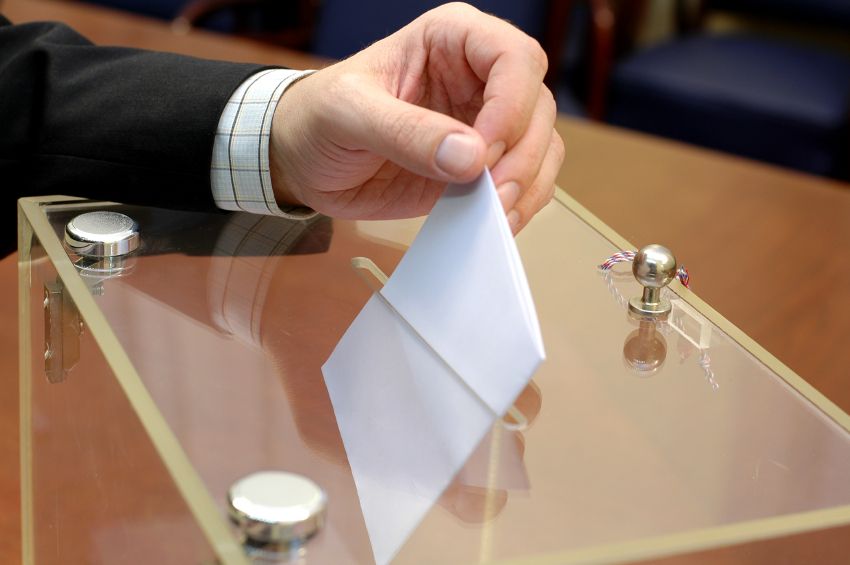 Person placing vote in ballot box