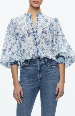 A model wears Alice +Olivia blue and white April Floral Blouson Sleeve Cotton Top