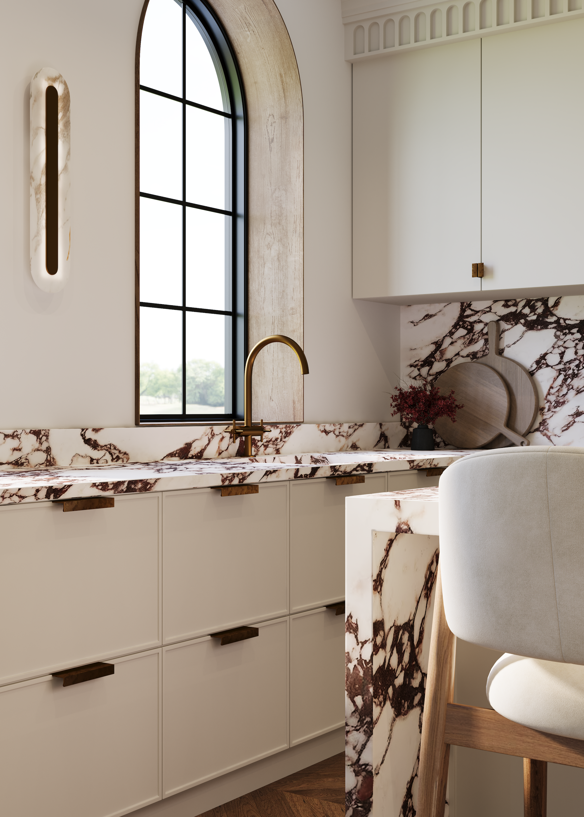 A sleek brass kitchen tap on a marbled kitchen countertop. There are also chopping boards on top of the counters