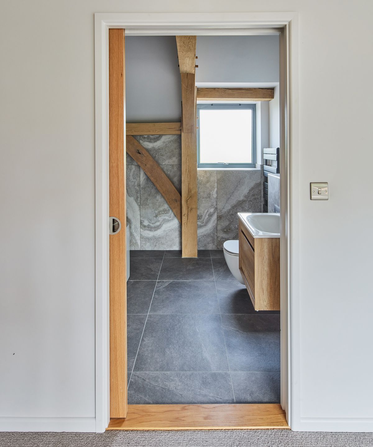 A doorway with an open sliding door leading into an ensuite bathroom