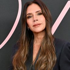 Victoria Beckham in black blazer with long brown hair with balayage