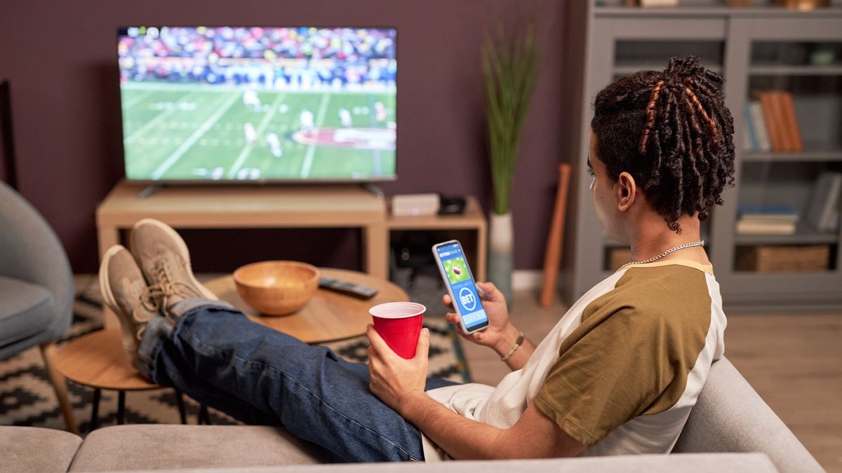 Watching football on tv with phone open to second-screen app