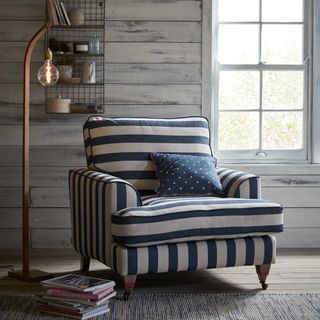 wooden living space with blue strips armchair and wooden lamp