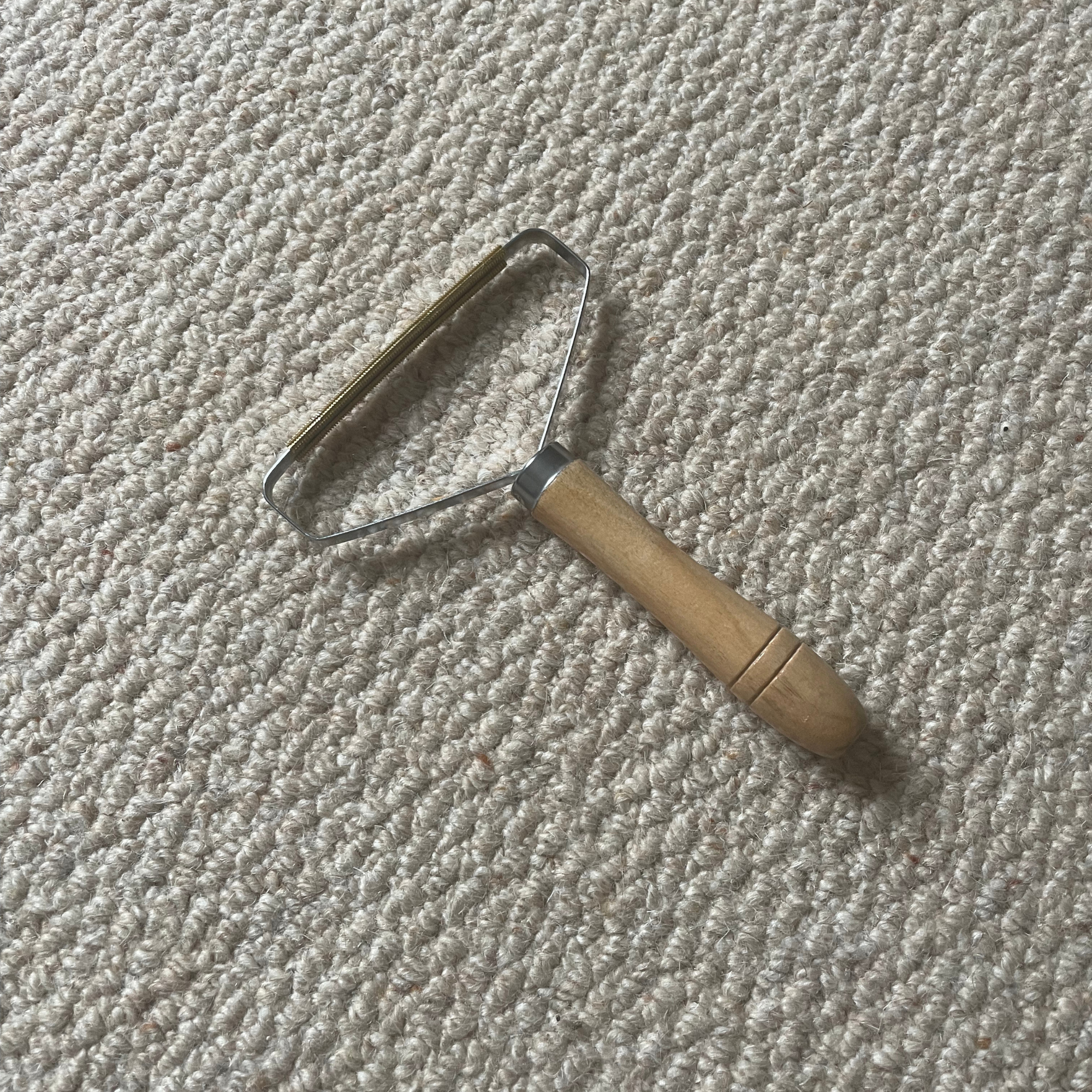 Carpet scraper laying on cream wool carpets