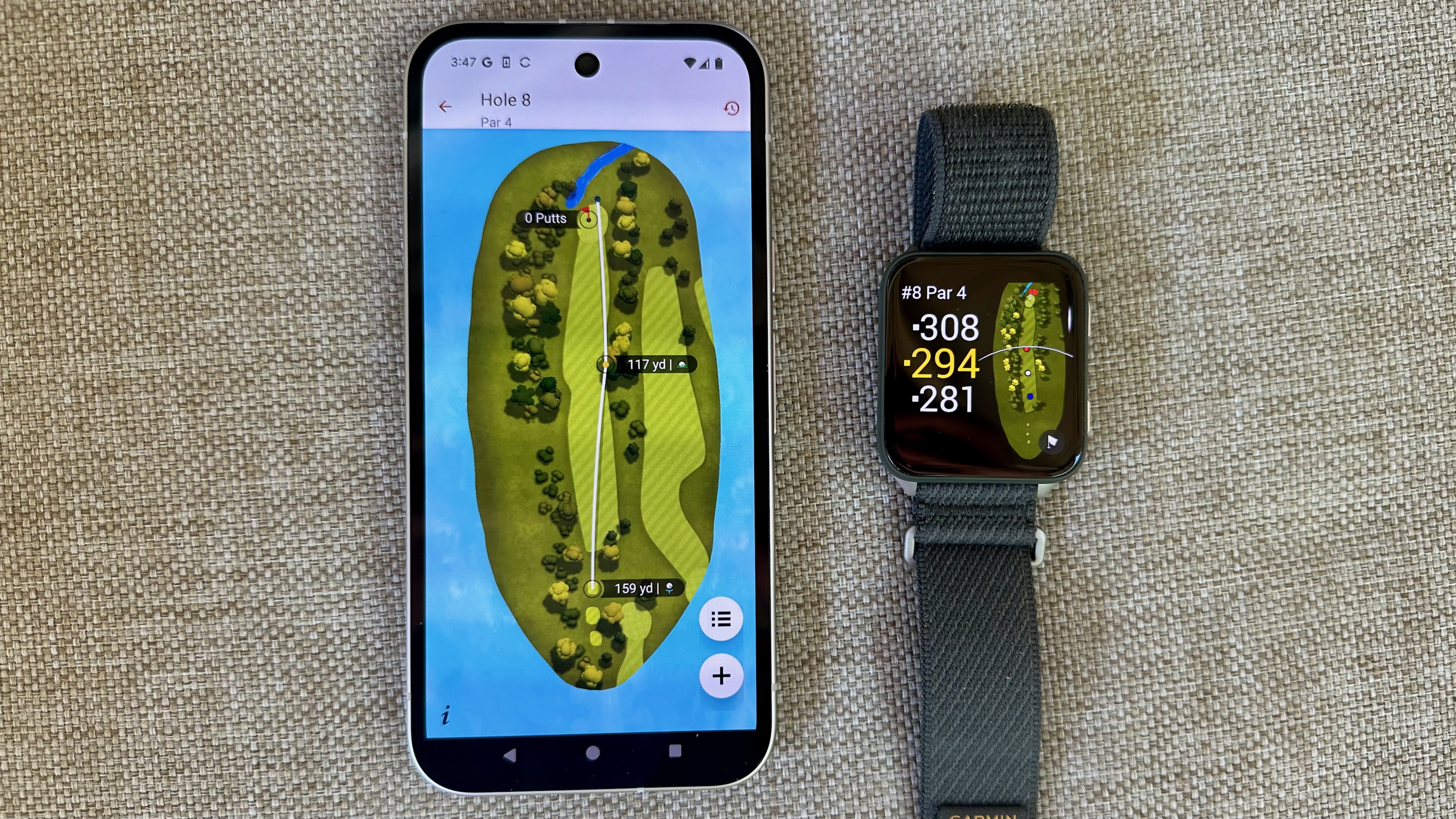 The Garmin Venu X1 next to a Google Pixel 9a, both showing a golf activity. The watch shows yardage for "Hole 8," while the phone shows the number of shots the author took on that hole.