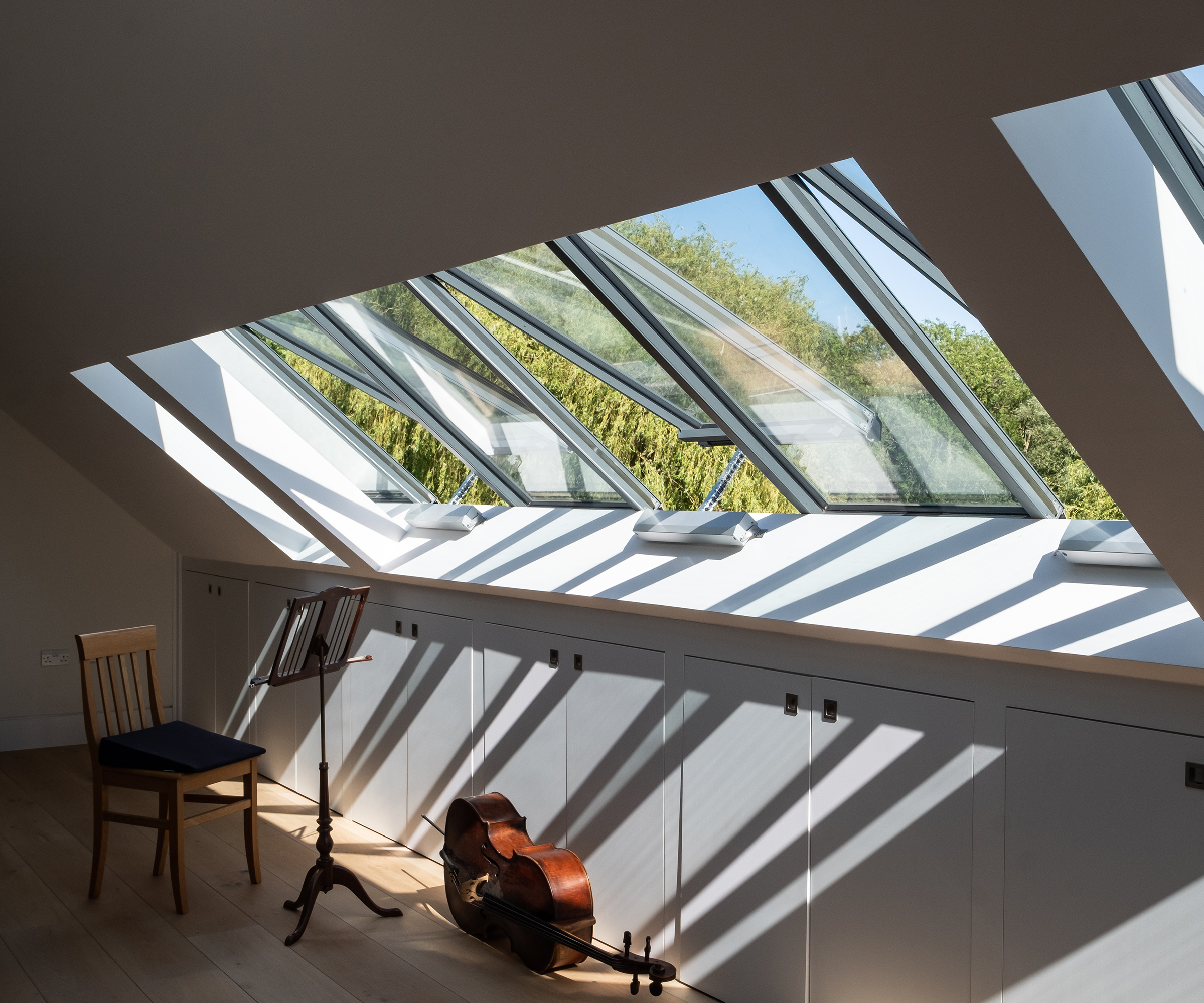 A row of Velux style roof glazing in a loft room with musical instrument