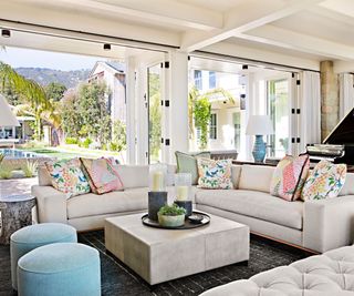living room with white sofas and blue footstools