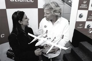 a woman and a man look at each other while holding a model spaceplane