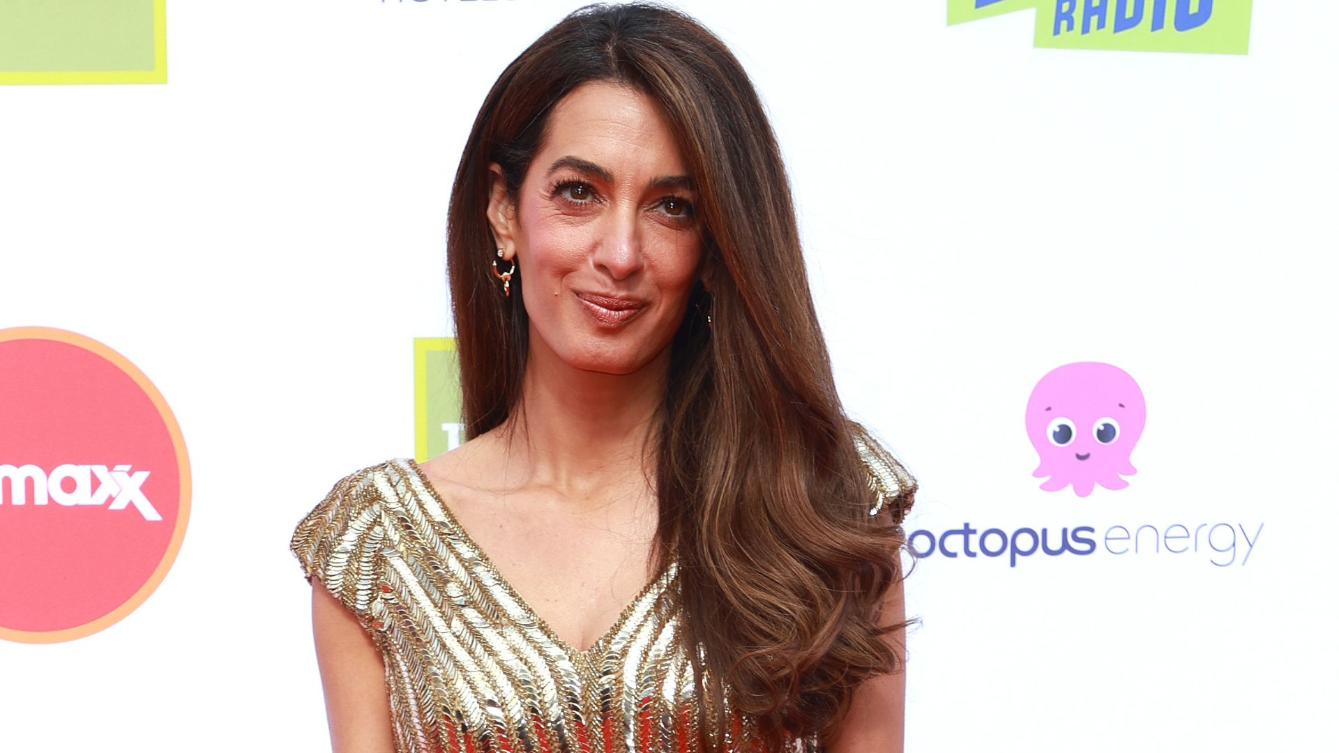 Amal Clooney pictured with a metallic dress and rich, truffle brunette hair
