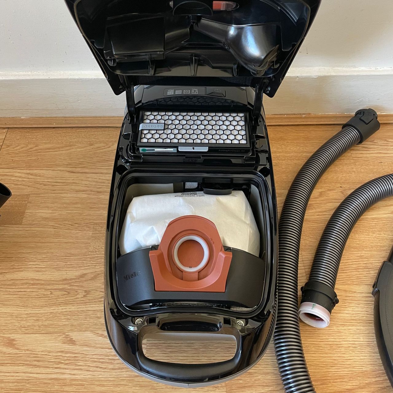 Miele Guard M1 Cat &amp; Dog with the dust lid popped open, looking at the dust bag within