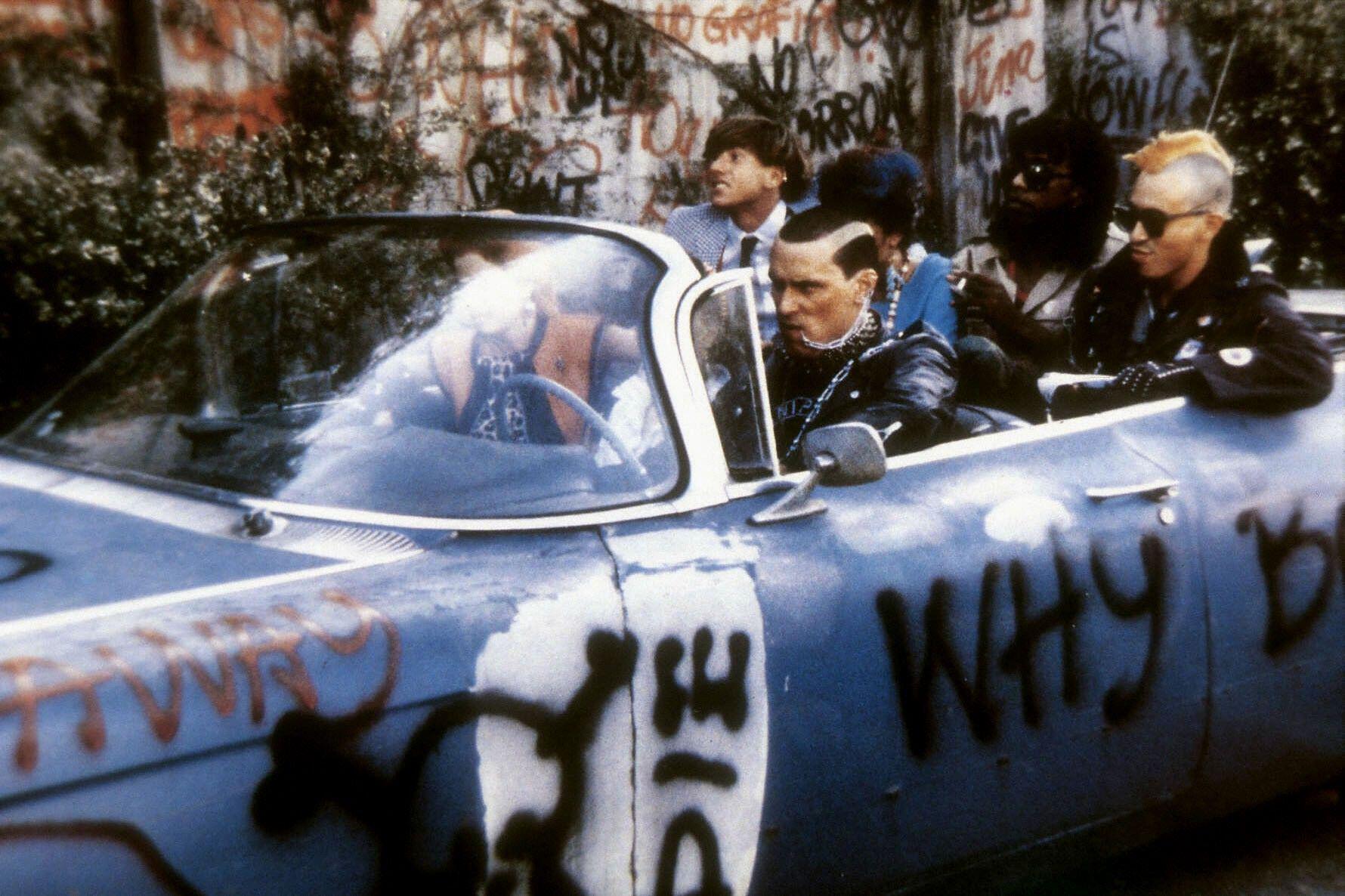 punks ride in a graffeti car in the return of the living dead