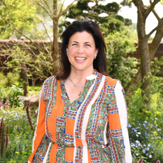 Kirstie Allsopp wearing an orange dress.