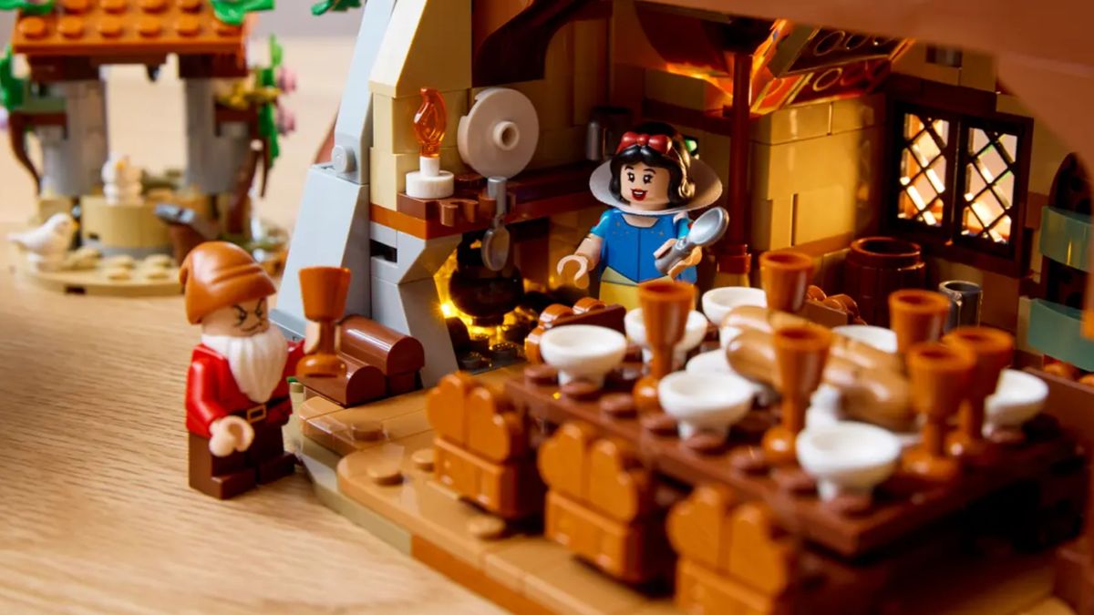 Lego Snow White and the Seven Dwarfs' Cottage set on a wooden table, with minifigures