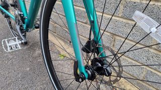 Close up of green fork legs on a bike with reflective accents