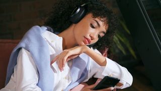 Woman wearing black Bowers & Wilkins PX8 headphones.