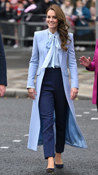 Kate Middleton in a blue coat and navy trousers