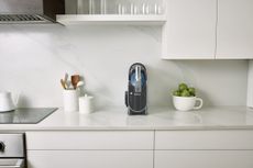 a ninja slushi in a small all white kitchen