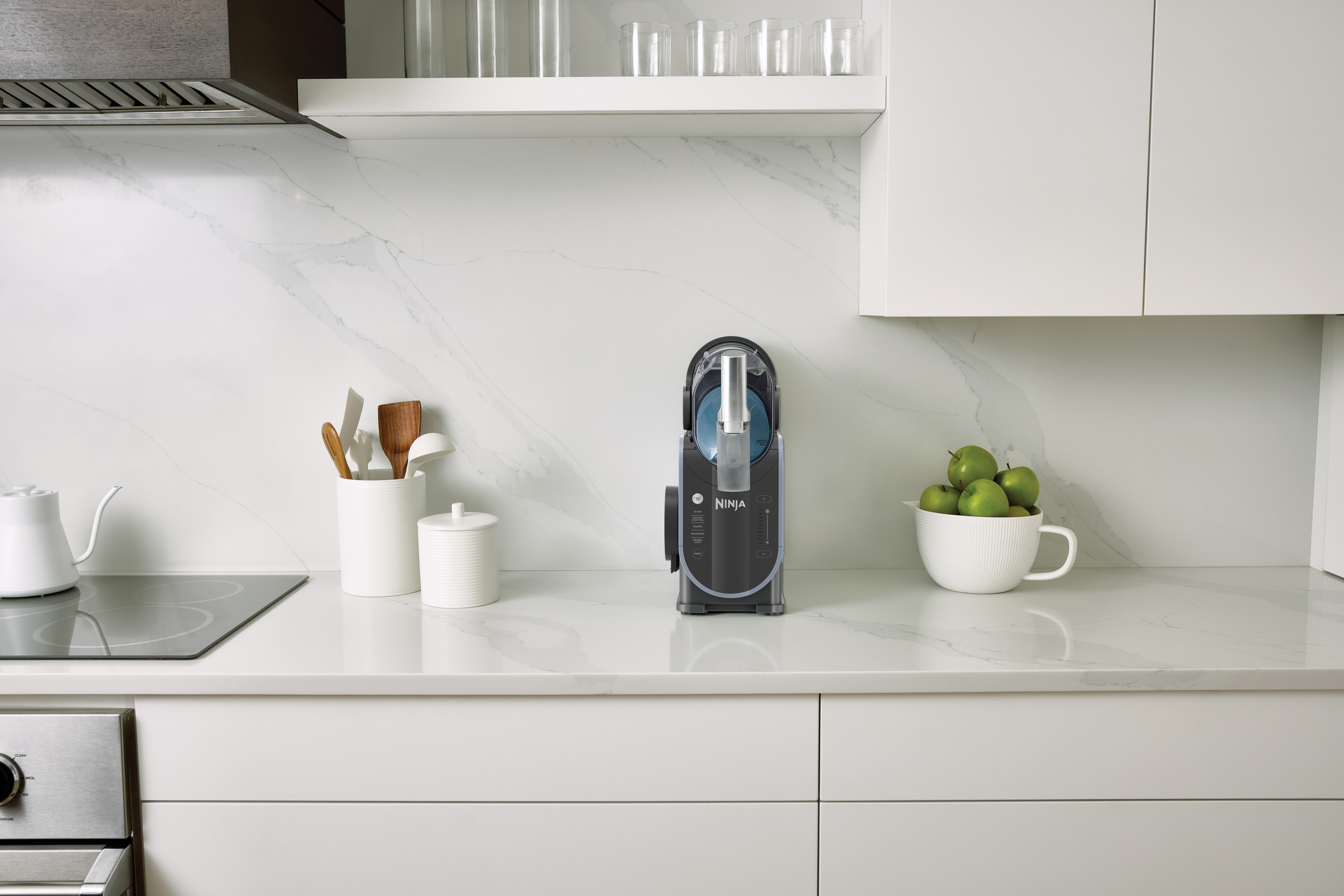 a ninja slushi in a small all white kitchen