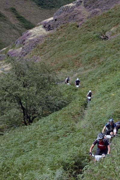 Riders roll along some singletrack.
