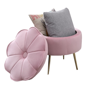 A blush pink flower-shaped storage footstool with two throw cushions