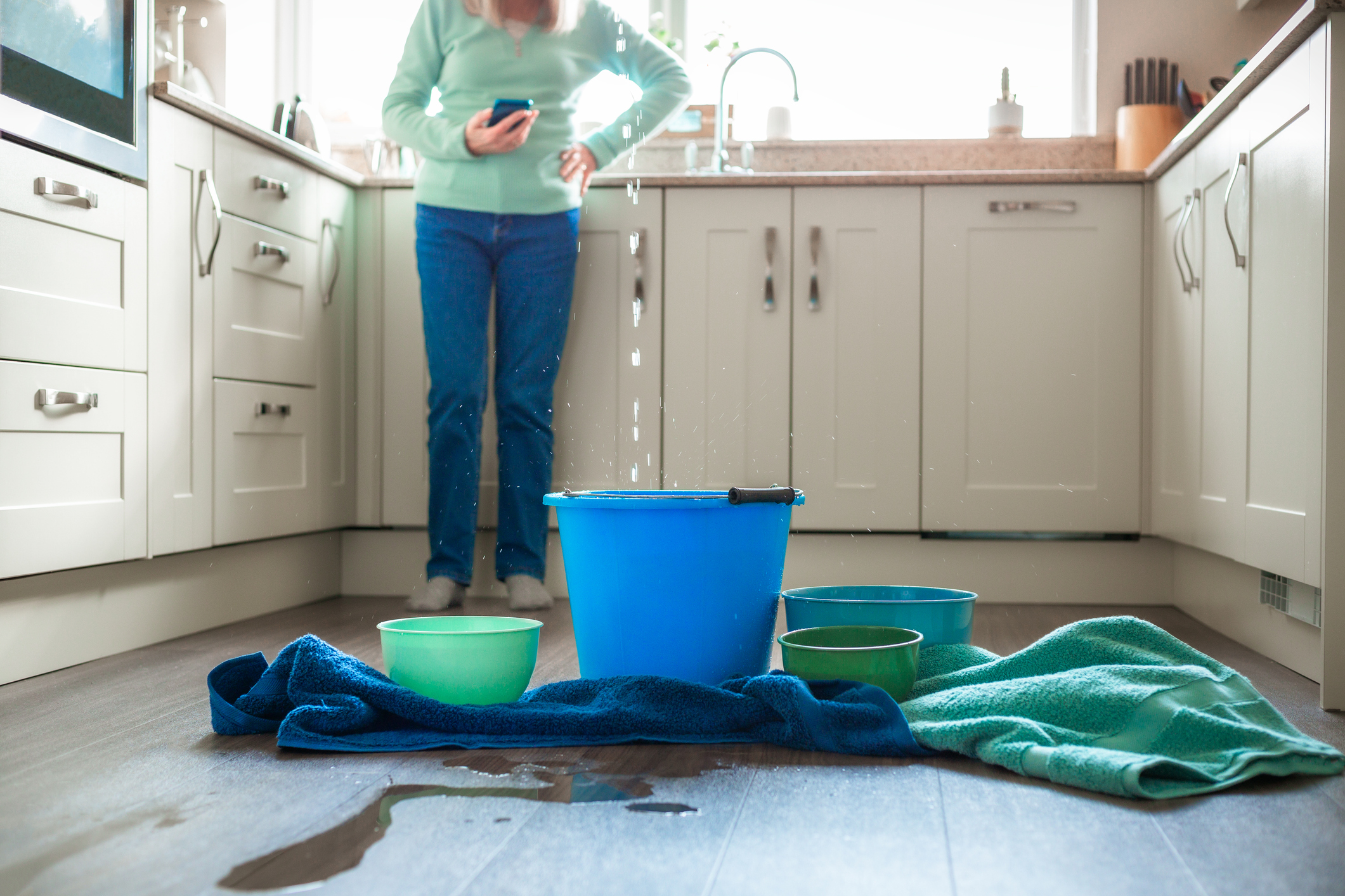 Worried home owner dealing with water leak in the kitchen