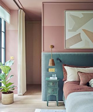 bedroom with pink walls and bed with oversized green headboard