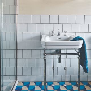 A bathroom with a pattern tiled floor