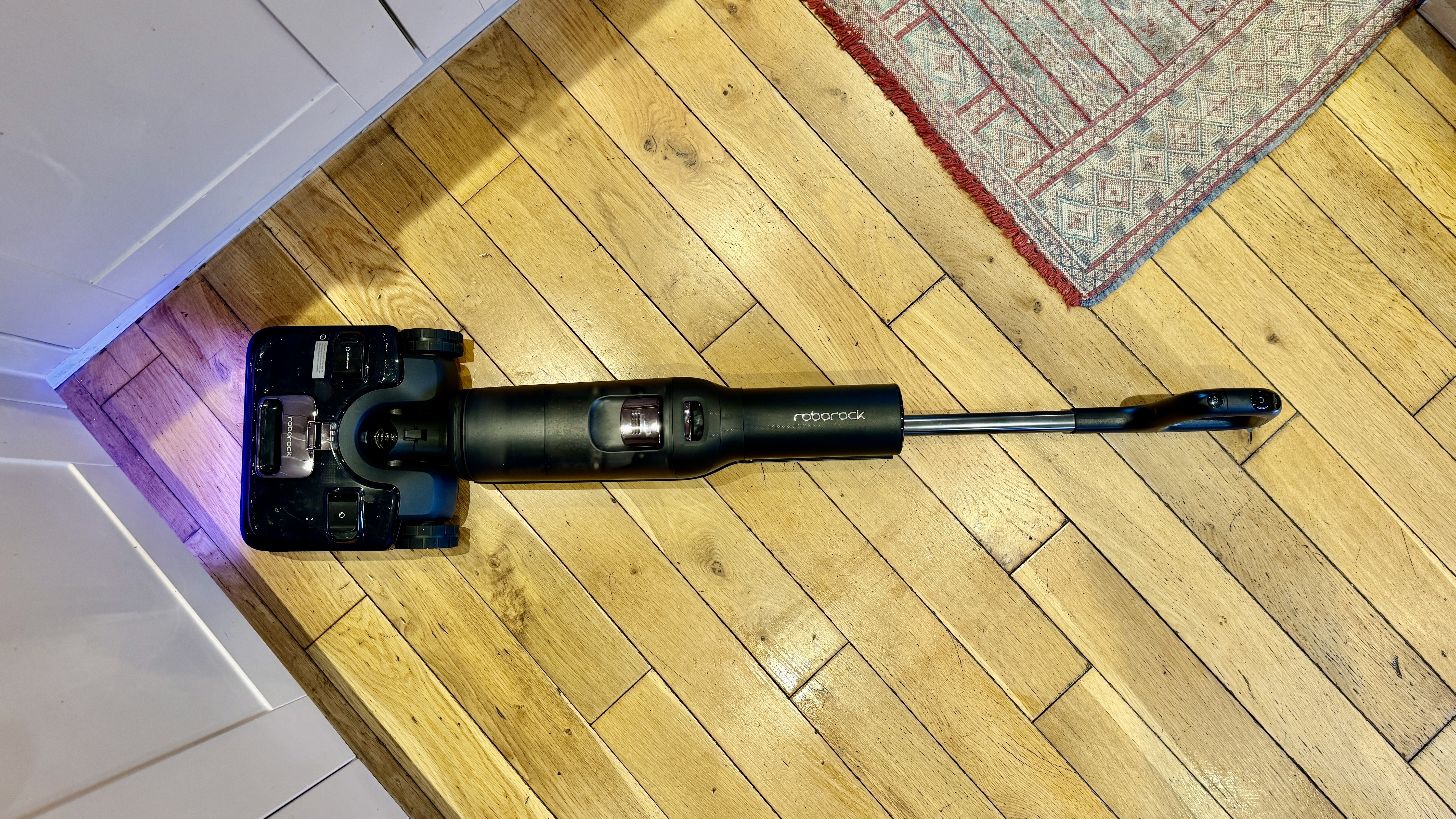Roborock F25 Ultra lying flat on a wooden floor as it cleans