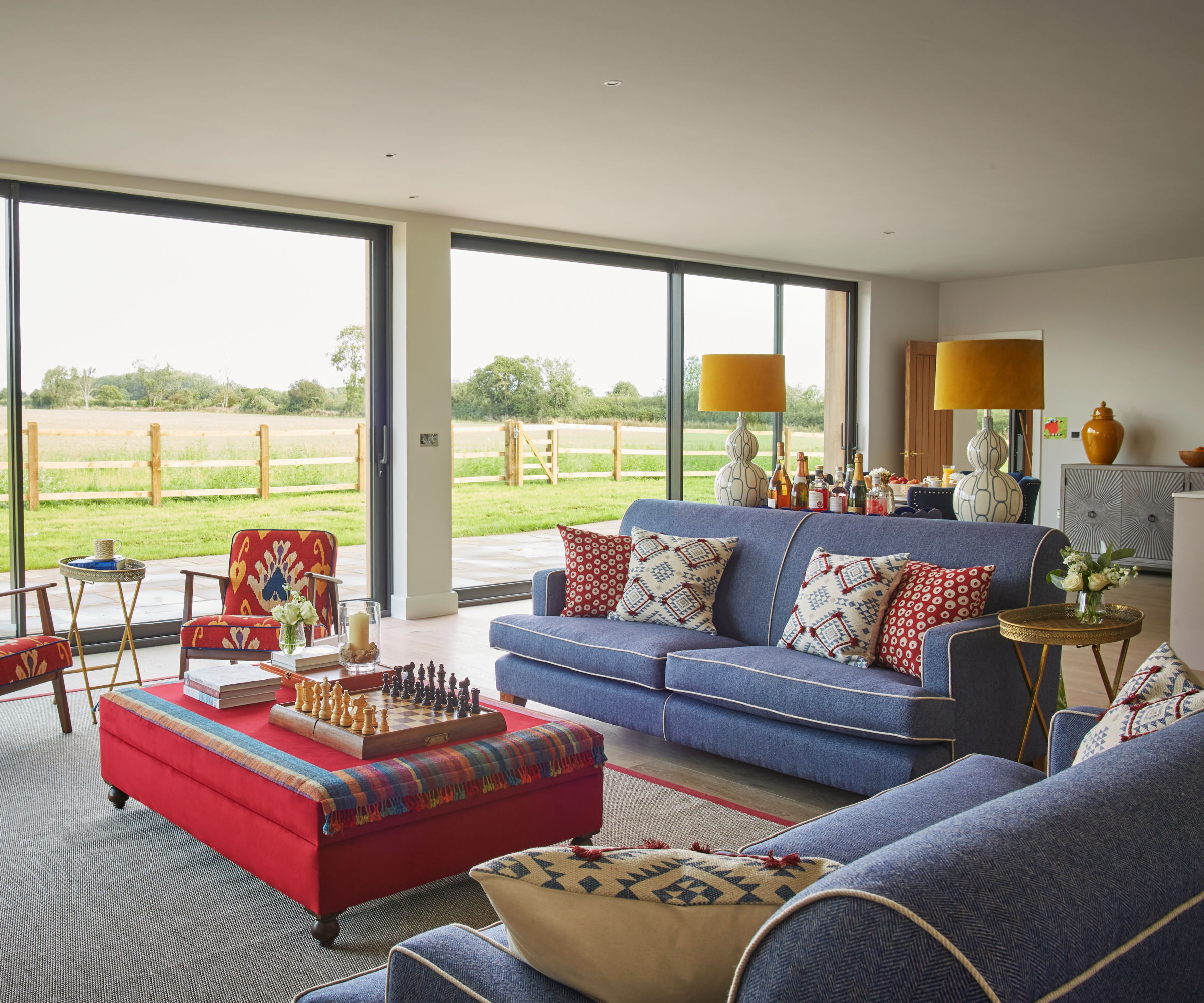 open plan living room with large patio doors and a red and blue furniture colour scheme