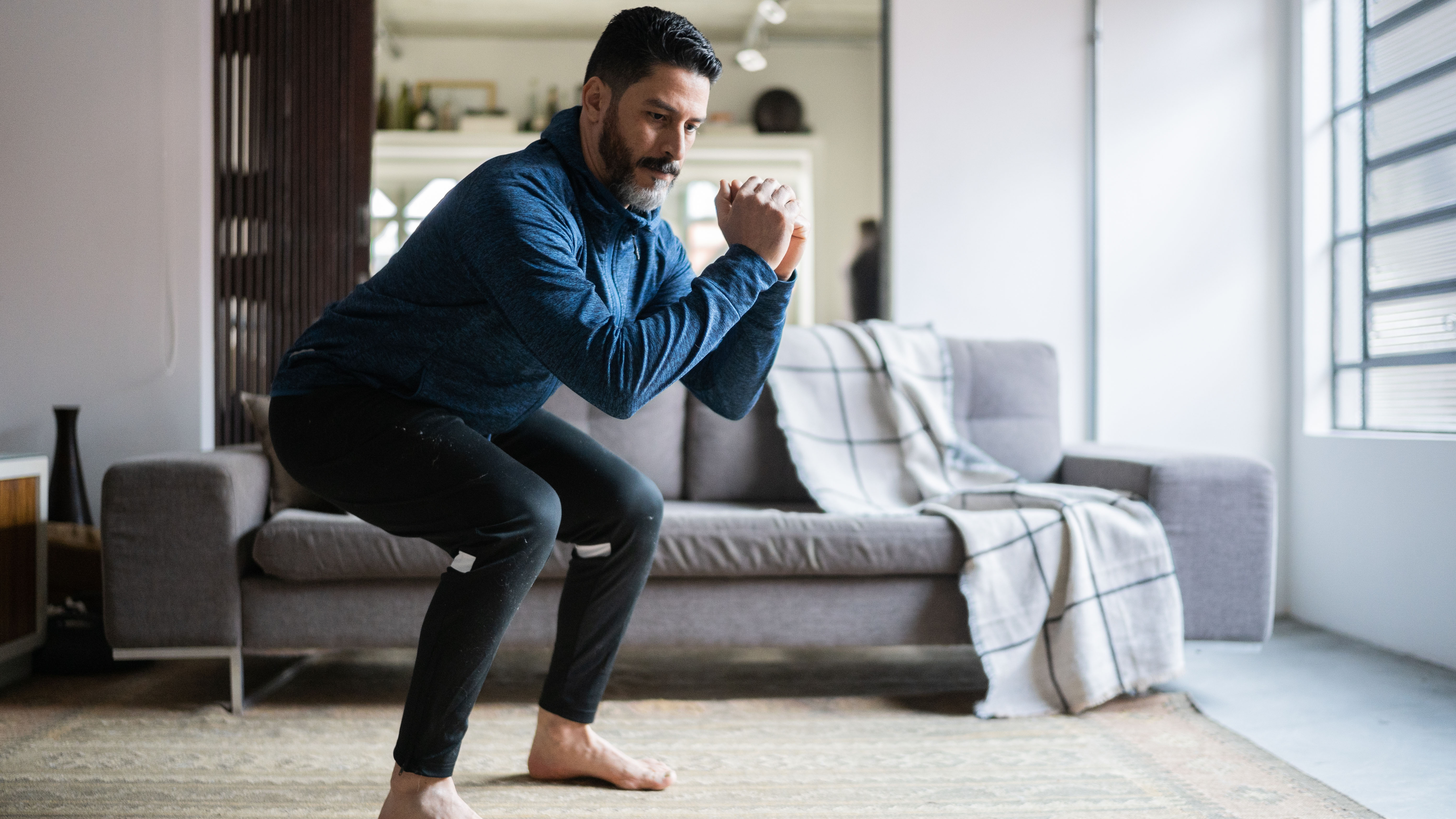 Man doing squats at home