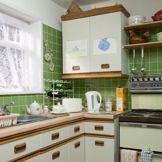 kitchen room with shelves on tiled green walls