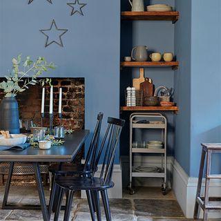 blue kitchen with black dining table and fire place