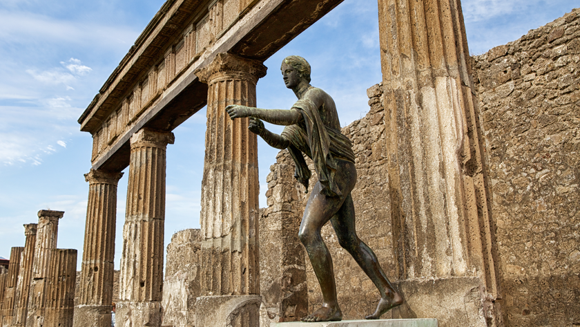 statue of Apollo in front of ruins of a temple at Pompeii