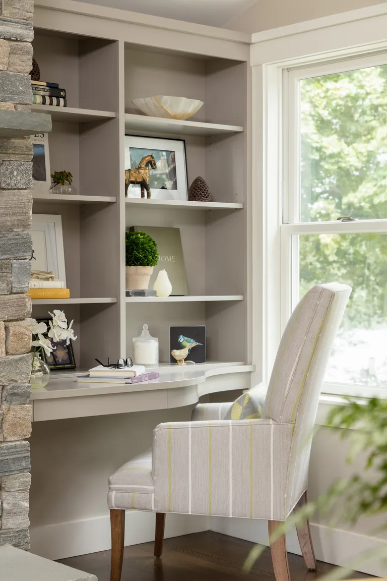 custom built home office/guest room office with upholstered stripe armchair, shelving, ornaments