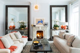 Two large mirrors fill the alcove on either side of the fireplace in the living room.