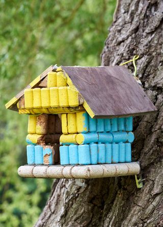 Birdhouse made with wine corks painted in blue and yellow