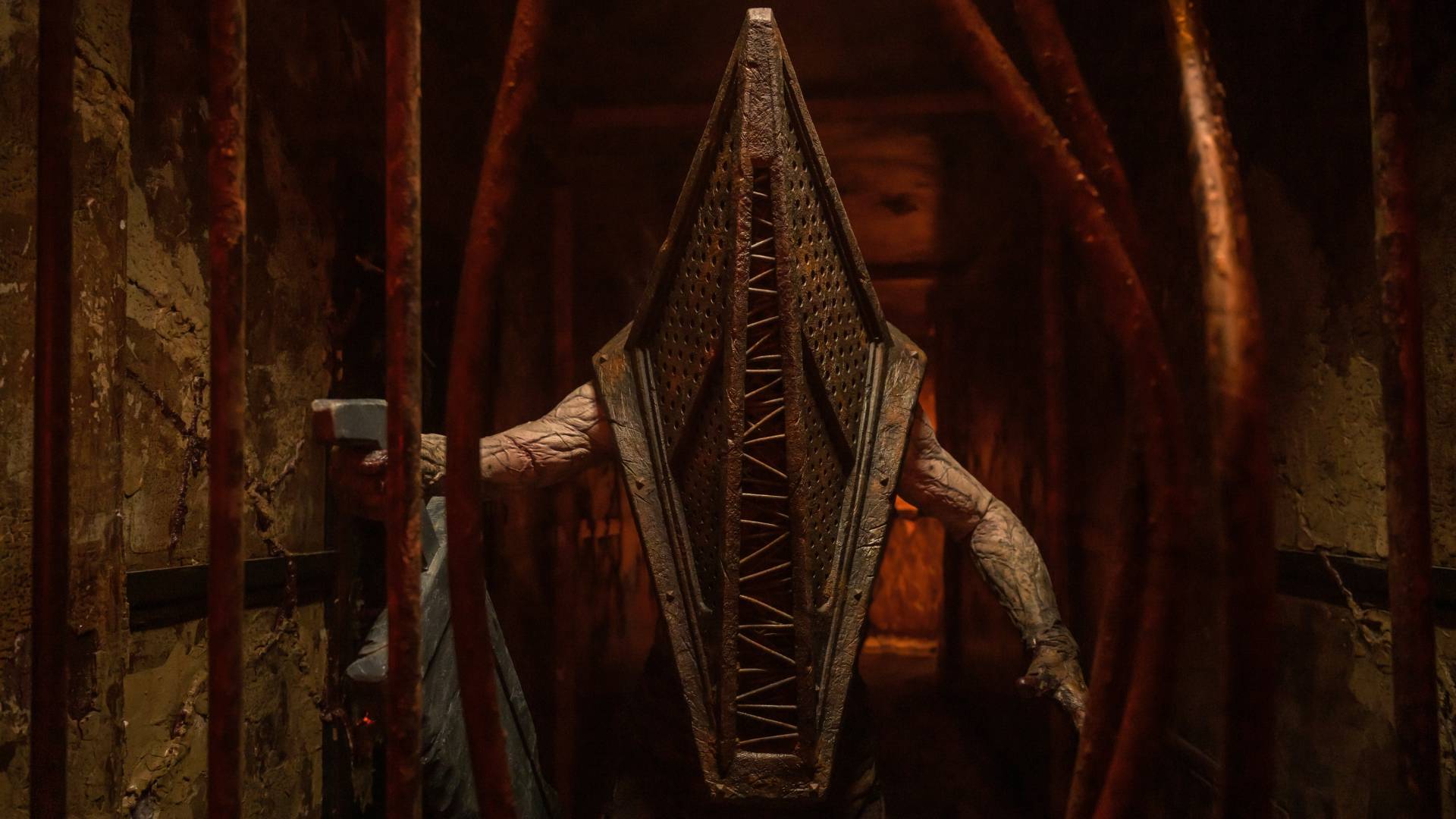 Pyramid head peering through bent bars in Return to Silent Hill