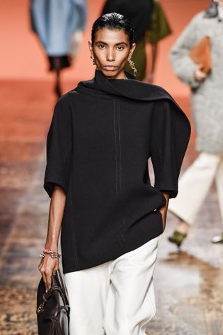 A model at Bottega Veneta wears a curled sweater