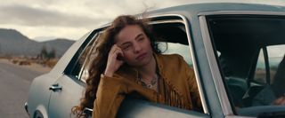 Autumn Best as Amy leaning out a car window in the desert in woman in the window