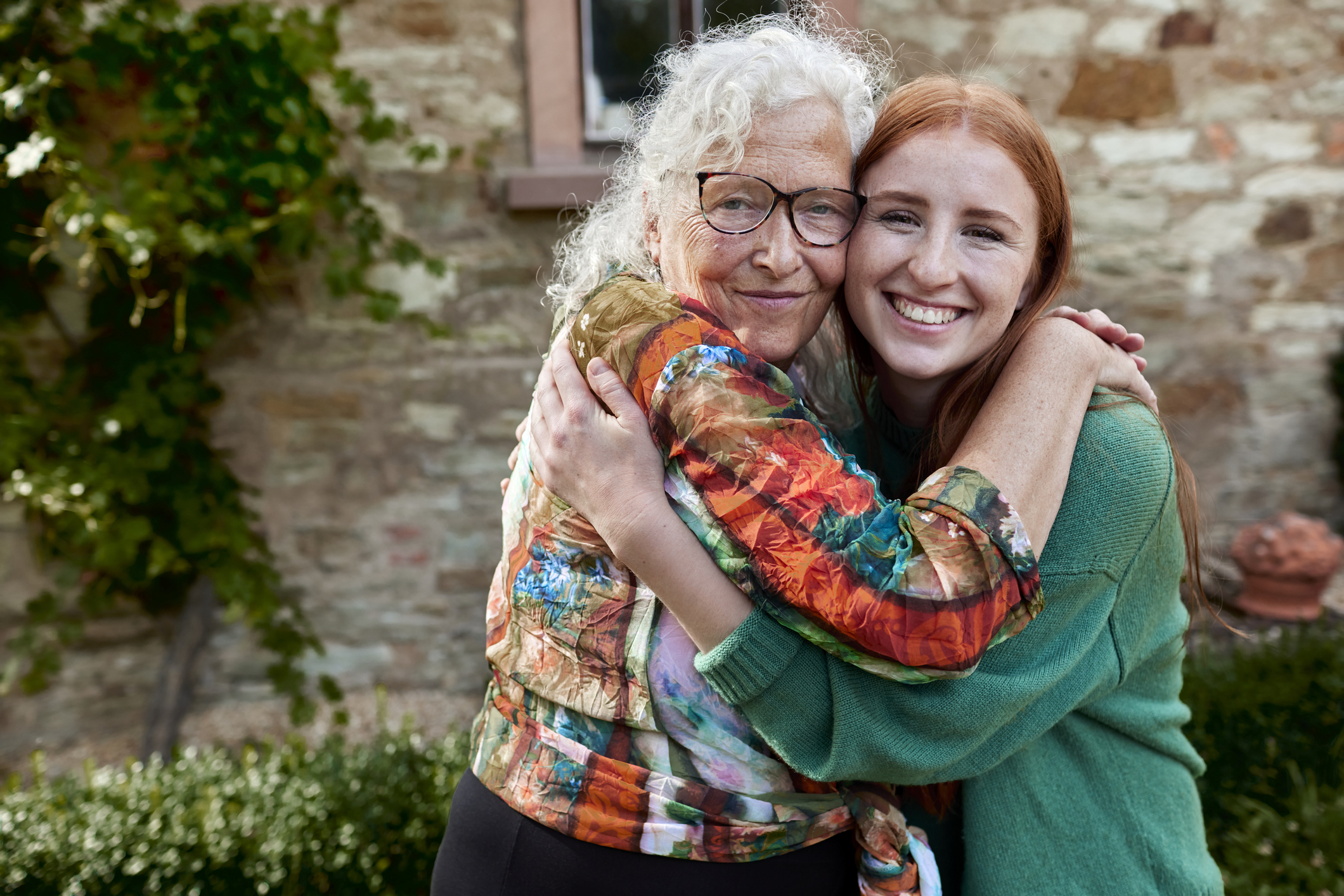 older woman and younger woman hug