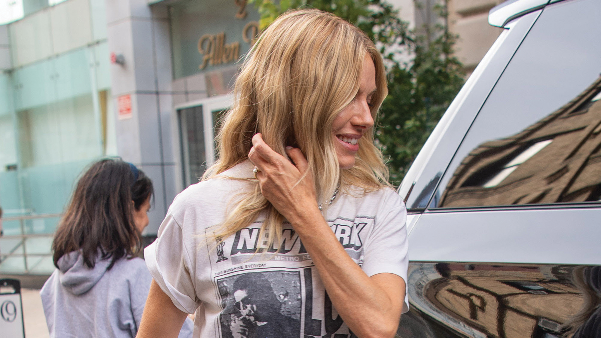 Sienna Miller is spotted greeting fans outside her hotel in New York City. The 44 year old actress wore a vintage New York Post Lou Reed concert t-shirt, jeans, and heels.