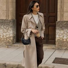 @michellelin.lin wears a trench coat, cardigan and wide-leg trousers whilst walking the streets of London