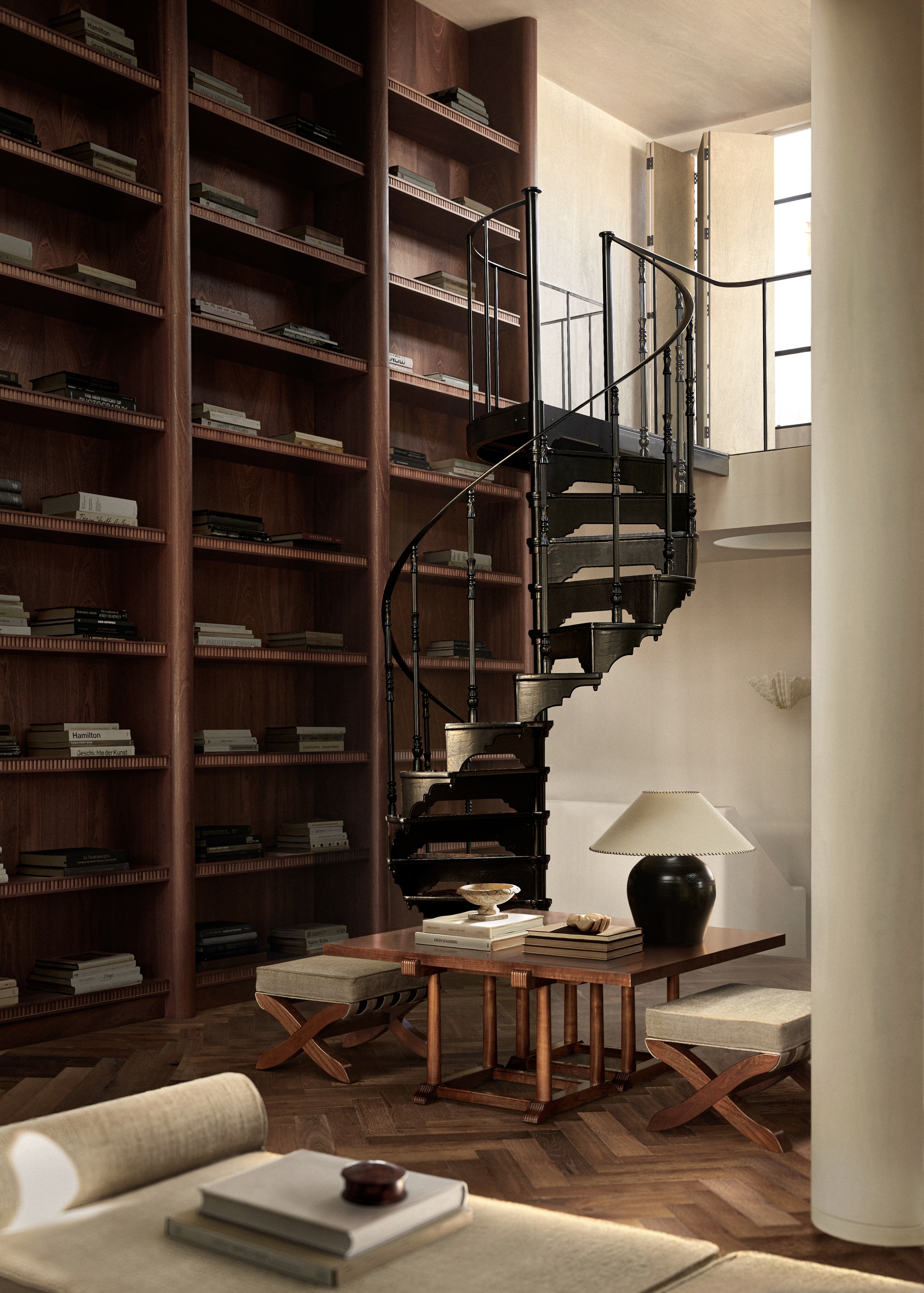 room with a bookshelf wall and a spiral staircase