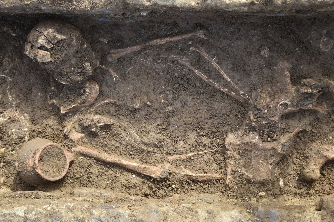 Tomb containing a person and a ceramic pot.
