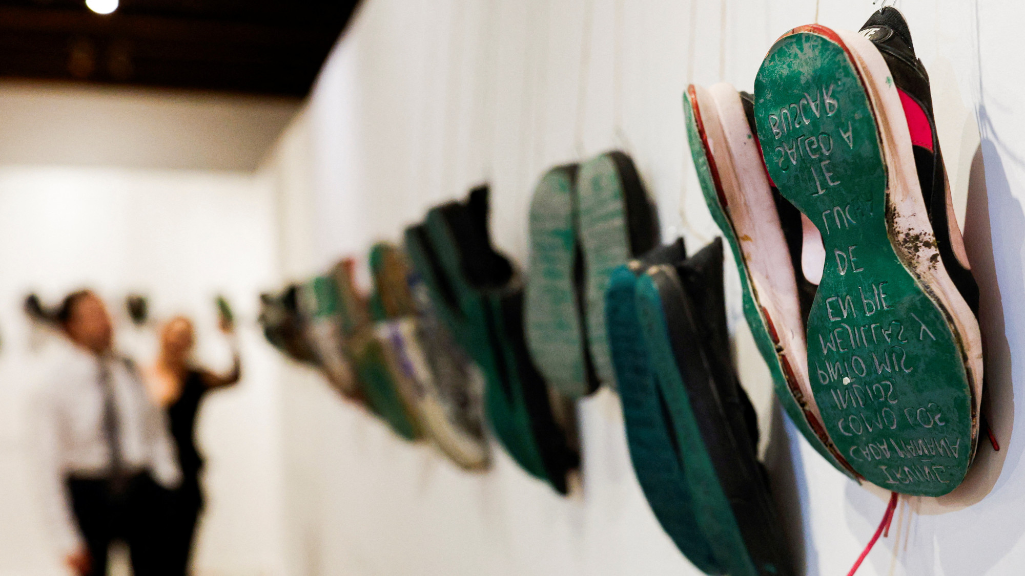 A pair of shoes hang from a wall