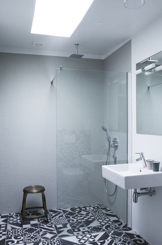 simple black white and grey bathroom with a walk in shower behind a glass screen