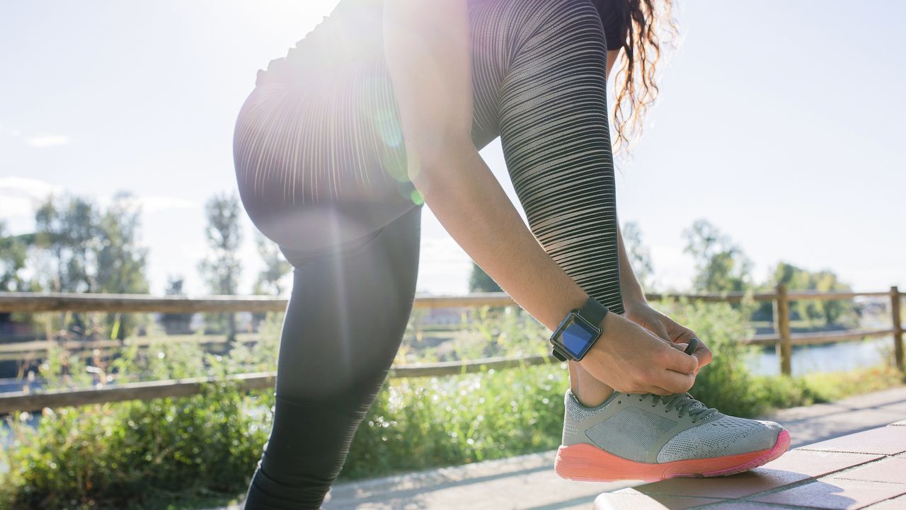 woman lacing up her shoes before an outdoor workout