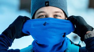 A man with blue eyes and a blue hat wearing a Ridge Merino Neck Gaiter in blue